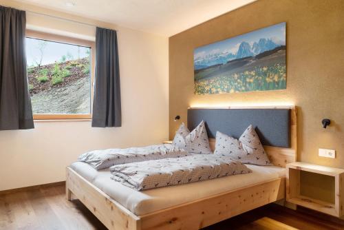 Schlafzimmer mit einem Bett mit Wandgemälde in der Unterkunft Ratscheinerhof App Gipfelglück in Latzfons
