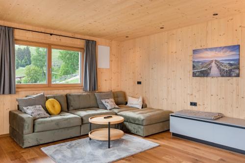a living room with a couch and a table at Ratscheinerhof App Waldruhe in Lazfons
