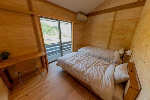 Habitación con 2 camas en una habitación con ventana en Guest House Amami Long Beach 2 - Vacation STAY 37974v, en Amami