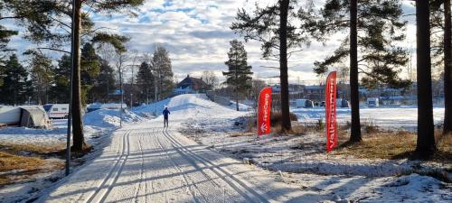 a person walking down a snow covered road at First Camp Moraparken - Dalarna in Mora
