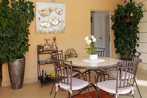 a dining room with a table and chairs and a plant at Sunshine Apartment Doda in Vela Luka