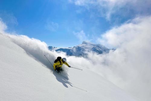 a person is skiing down a snow covered mountain at Apartment next to Titlis Station in Engelberg