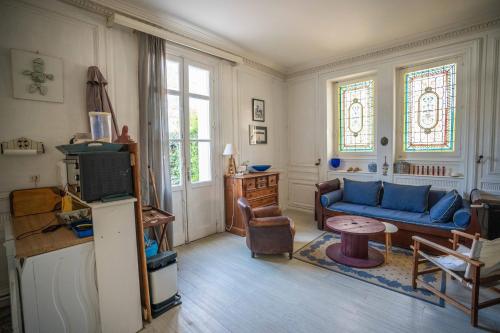 un salon avec un canapé bleu et une table dans l'établissement ATYPIQUE T2 de 35 m avec JARDIN proche de la MER, à Arcachon