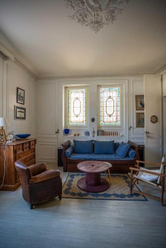 un salon avec un canapé bleu et une table dans l'établissement ATYPIQUE T2 de 35 m avec JARDIN proche de la MER, à Arcachon