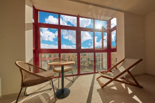a room with a large window with chairs and a table at Fil Suites in Palma de Mallorca