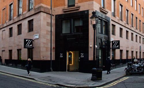 a woman walking down a street in front of a building at The Z Hotel Trafalgar in London