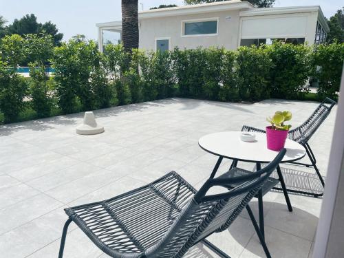 a patio with two chairs and a table at SALAPIA SALIS RESORT in Margherita di Savoia