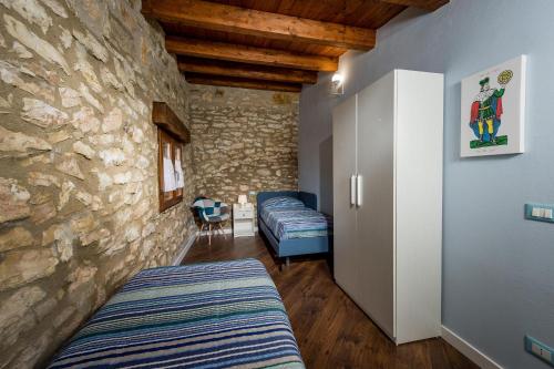 a bedroom with two beds and a stone wall at Villa Stone Walls with Jacuzzi in Castellammare del Golfo