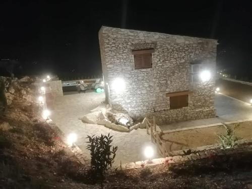 a stone building with lights in front of it at night at Villa Stone Walls with Jacuzzi in Castellammare del Golfo