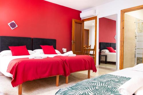 a red bedroom with two beds and a red wall at 1D Apartamento con vistas a la Alhambra in Granada
