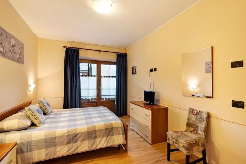 una camera con letto, sedia e specchio di Appartamento Greta Baita Mauri a Livigno