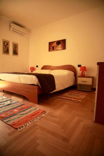 a bedroom with a large bed and a wooden floor at La Torre in Tirano