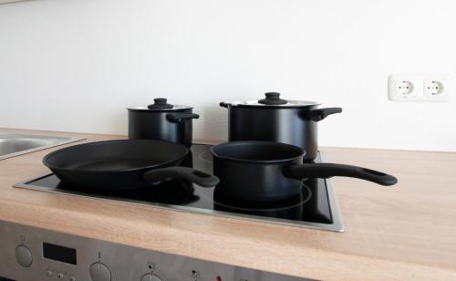two pots and pans sitting on top of a stove at Tolstov Apartments - 3 Room Apartments with Garden - 20 Min Messe DUS & Airport DUS in Meerbusch