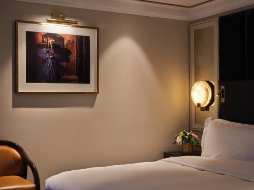 a bedroom with a bed and a picture on the wall at The Mayfair Townhouse - an Iconic Luxury Hotel in London