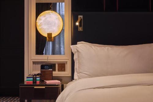 a bedroom with a white bed and a window at The Mayfair Townhouse - an Iconic Luxury Hotel in London