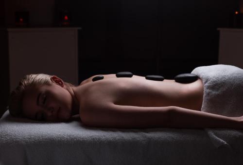 a naked woman laying on a bed with a towel at Bishopstrow Hotel and Spa - Small Luxury Hotels of the World in Warminster