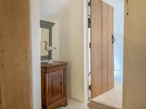 a hallway with a door to a room with a mirror at Rose Cottage in Holcombe in Dawlish