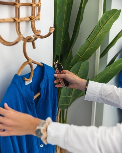 two people are helping another person hang blue shirts at Hotel de La Plage - Mahogany in Cassis