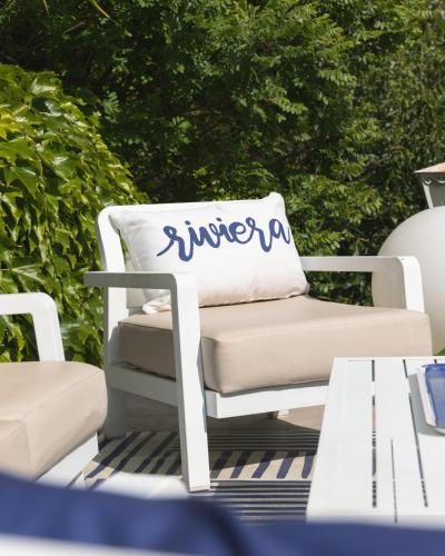 a white chair with a pillow on a patio at Hotel de La Plage - Mahogany in Cassis