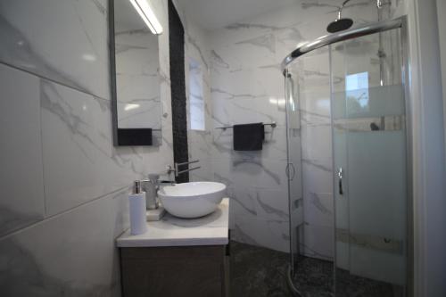 a bathroom with a sink and a glass shower at Casa do Milho in Carvoeiro