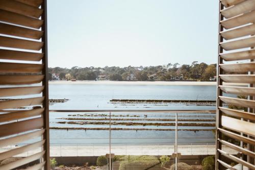 a view of the lake from the balcony of a building at Hôtel & Spa Villa Seren in Hossegor