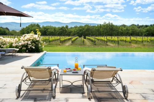 a table and two chairs next to a swimming pool at Il Borro Relais & Châteaux in San Giustino Valdarno