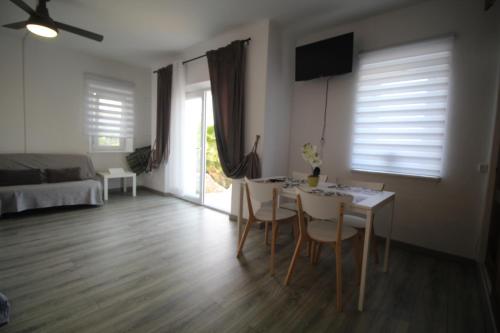 a living room with a table and chairs and a bedroom at Casa do Milho in Carvoeiro
