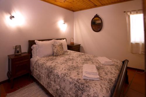 um quarto com uma cama com duas toalhas em Casas do Casinhoto - Casa do Cabo em Baião