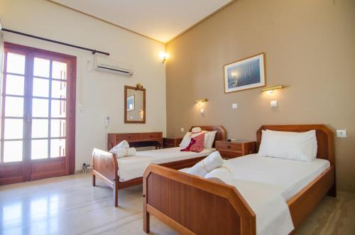 a hotel room with two beds and a window at Almira Inn in Ios Chora