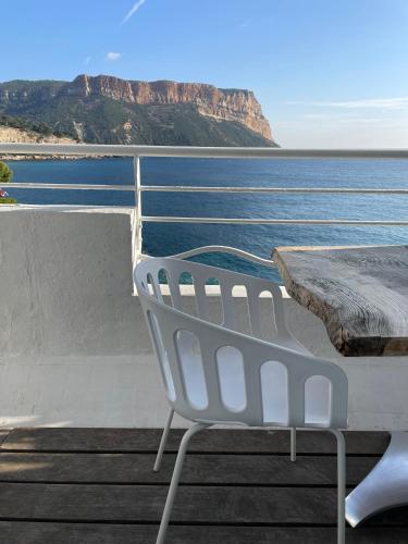 a white chair sitting in front of the ocean at Hotel de La Plage - Mahogany in Cassis