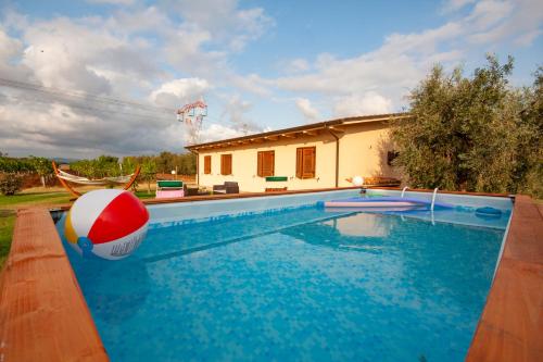 a pool with a beach ball in front of a house at Agriturismo L'Istrice di Giò in Montalto di Castro