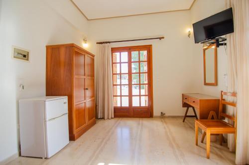 a kitchen with a refrigerator and a table and a desk at Almira Inn in Ios Chora