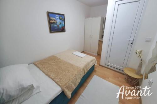 a small bedroom with a bed and a closet at Apartmani Avanti Becici in Becici