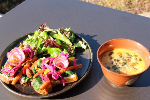 a plate of food with a salad and a bowl of soup at Hôtel & Spa Villa Seren in Hossegor