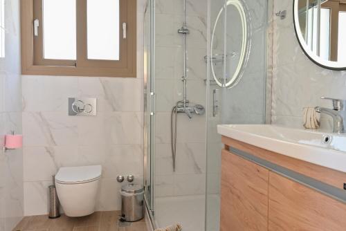 een badkamer met een douche, een toilet en een wastafel bij Villa Ioanna in Liapades