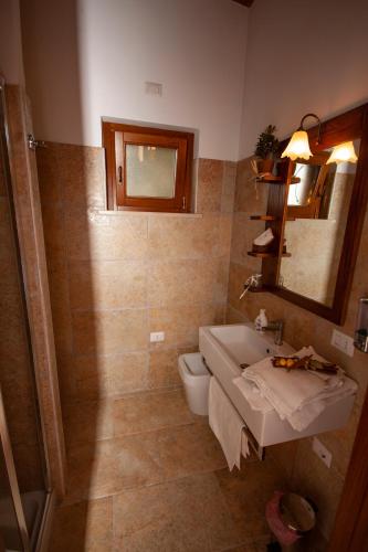 a bathroom with a sink and a toilet and a mirror at Agriturismo L'Istrice di Giò in Montalto di Castro