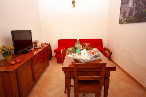 a living room with a table and a red couch at Agriturismo L'Istrice di Giò in Montalto di Castro