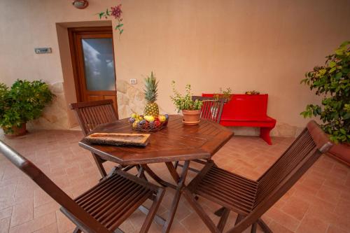 a wooden table and chairs with a bowl of fruit on it at Agriturismo L'Istrice di Giò in Montalto di Castro