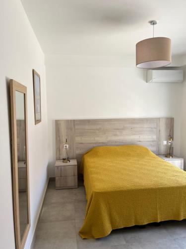 a bedroom with a bed with a yellow blanket at Casa Olmia Résidence in Calvi
