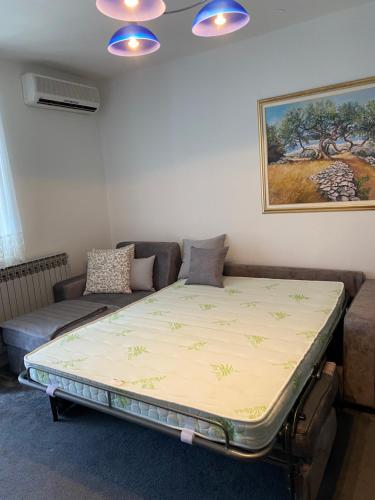 a large bed in a living room with a couch at Apartman Njivice in Njivice