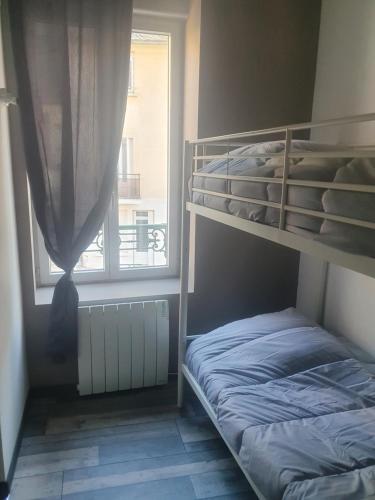 een slaapkamer met een stapelbed en een raam bij Bienvenue chez les ch'oups le loft 50 m2 in La Bourboule