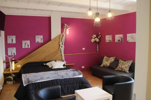 a bedroom with purple walls and a bed and a couch at B&B degli Allori in Moggiona