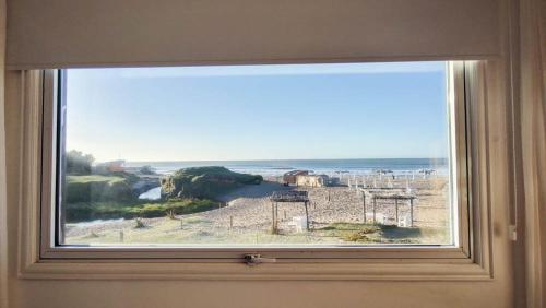 a window in a room with a view of the ocean at Playa Luna Roja in Chapadmalal