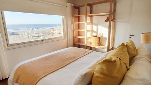 a bedroom with a bed and a large window at Playa Luna Roja in Chapadmalal