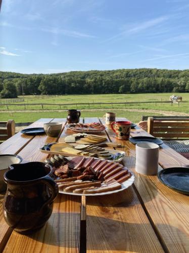 a wooden table with a plate of food on it at Kerca Bio Farm in Kercaszomor