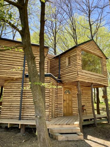 a log cabin with a porch and a wooden door at Kerca Bio Farm in Kercaszomor