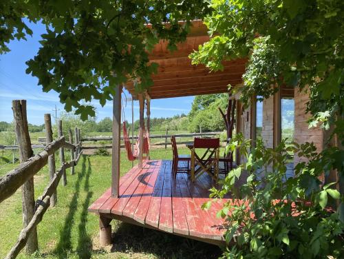 eine Holzterrasse mit einem Tisch und Stühlen auf einer Hütte in der Unterkunft Kerca Bio Farm in Kercaszomor