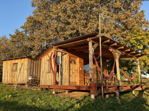 a wooden cabin in the grass in a field at Kerca Bio Farm in Kercaszomor