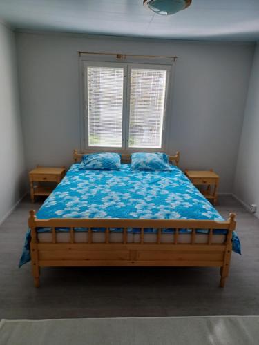 HUONEISTO 3 RISTIMÄENKATU في سافونلينّا: غرفة نوم بسرير وملاءات زرقاء ونافذة