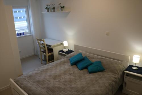 - une chambre avec un lit et 2 oreillers bleus dans l'établissement Apartment D&E Punat - free parking and Wi-Fi, à Punat